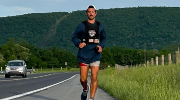Officer Andrew Linder running along a highway for Pier to Park