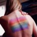 woman with Pride flag on her back. Addressing and Preventing Trafficking of LGBTQ People