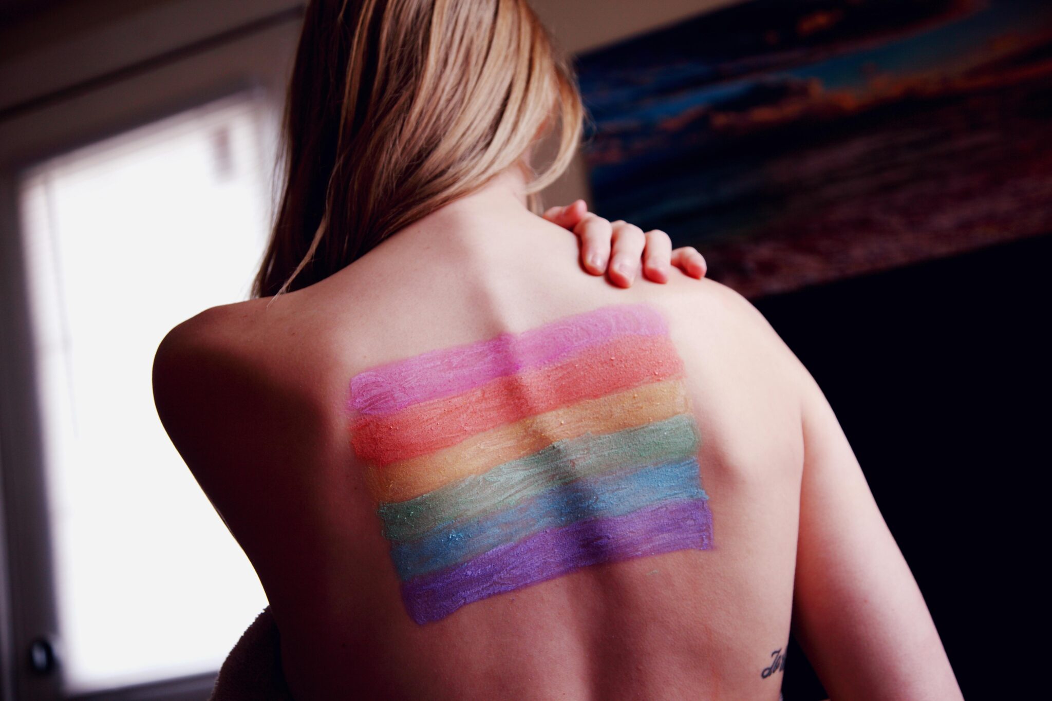 woman with Pride flag on her back. Addressing and Preventing Trafficking of LGBTQ People