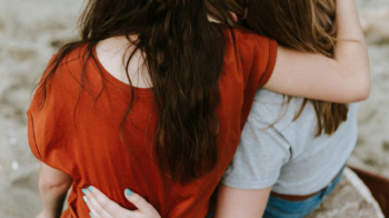 women with arms around each other's shoulders Domestic Violence Awareness Month