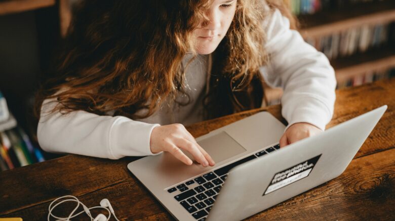 young female student on laptop for internet safety blog